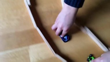 Oyuncak arabaları tahta blok yolda iten eller, yerde oyuncu ve yaratıcı kapalı alan aktivitelerine yakın çekim, yaratıcı oyun zamanı