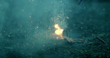 Havai fişekler yavaş çekimde kıvılcımlar ve duman yayarak arka planda bulanık bir zemine doğru dramatik bir ateşleme ve enerji patlaması yakalıyorlar.