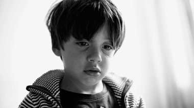 Ağladıktan sonra gözyaşı döken genç bir çocuğun siyah-beyaz görüntüsü. Kapalı mekanda duyguları sindirirken başını hafifçe eğmiş.