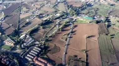 Tarlaları, yolları ve küçük yerleşim yerleri olan kırsal alanların hava görüntüsü tarlaları ve yukarıdan çevreleyen kırsal alanları gösteriyor.