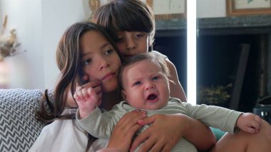 Çocuklu bir anne, yatakta oturuyor, bebek yakınlarda yatarken telefona bakıyor. sahne, aile bağlarını, dijital etkileşimi ve rahat bir ev ortamını yansıtır