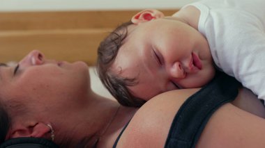 Bebeğin anne göğsünde huzurlu bir şekilde uyuması, sakin ve samimi bir anda dinlenmesi, ebeveynler ve çocuklar arasındaki sıcaklık ve bağ sessiz bir evde.