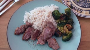 Pilav, brokoli ve dilimlenmiş et, taze hazırlanmış, dengeli yemek, sağlıklı ve davetkar bir sunum, iştah açıcı bir akşam yemeği.