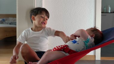 Küçük bir çocuk, bir fedainin yanında çömelmiş, evde sevgi ve ilgi gösteren hassas bir aile anını seyrediyor ve ona bağlanıyor.