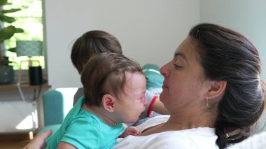 Bebek annesinin kollarında ağlarken ağlayan abim evde aile dinamiklerini ve bakımı gösteriyor. Duygular ve şefkat paylaşılıyor.