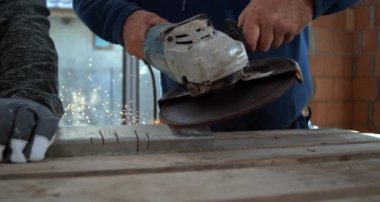 Closeup of worker using angle grinder on metal, sparks illuminating hands, focus on precision and teamwork in construction setting, 800 fps slow motion