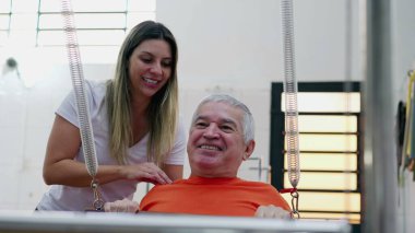 Pilates Kadın Koçu 'nun yardımıyla egzersiz yapan mutlu kıdemli adam. Yaşlı insan rutin egzersiz yaparak güç ve refah kazanıyor..