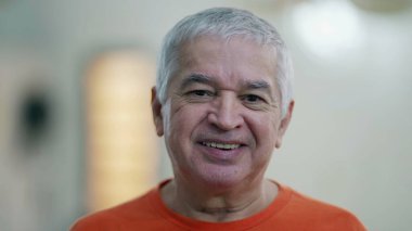 Kameraya bakan mutlu kıdemli adam. Yaşlı, gülümseyen beyaz bir adamın portresi..