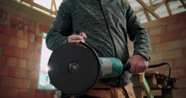 İnşaat işçilerinin yakın plan çekimleri, açı öğütücü, el ve aletlere odaklanma, miğfer ve güvenlik gözlükleri, endüstriyel çevre, inşaat araçları, elektrikli alet kullanımı