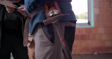 Çalışma kemerindeki inşaat aletine yakın çekim, tamamlanmamış yapıda kemerden sallanan inşaatçı çekici, inşaat ve endüstriyel işyeri ekipmanları