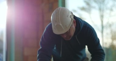 İnşaat işçisi yerde odun testeresi, el testeresi ile yakın plan, kapalı alanda ahşap kesme, ayrıntılı işçilik