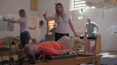 Pilates Eğitmeni Vücut Güçlendirme Egzersizinde Kıdemli Adamlara Rehber, Yaşlılara Yaşam Tarzında Formda Destekleme.