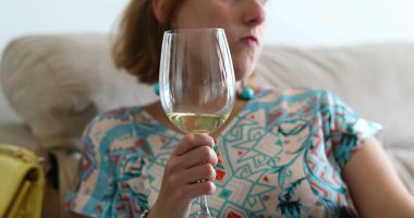 Sohbeti dinlerken elinde şarap kadehi tutan genç bir kadın.