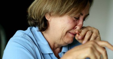 Burnunu kaşıyan biri. Yaşlı kadın yüz alerjisine karşı masaj yapıyor.