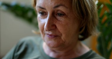 Yaşlı kadın, yuvarlanan gözler ve elleriyle sürtünen yüz.