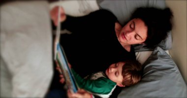 Anne yatmadan önce bebek için masal okuyor.