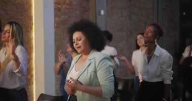 Kilisede ruhani bir toplantı sırasında gözleri kapalı dua eden bir kadın, dingin bir ibadetle duygularını ve bağlılığını ifade ediyor.