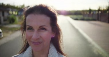 Kadınların yüzlerindeki sıcak gülümseme, yukarı bakıyor ve sakin bir banliyö caddesinde gözlerini gökyüzüne açıyor. Mutluluk ve düşünceyi yansıtıyor.