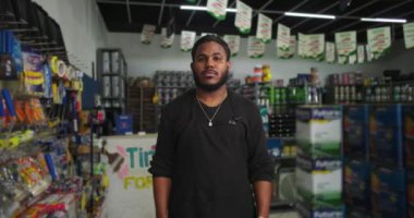 Boya kutuları ve malzemelerle çevrili Afrikalı Amerikalı adam perakende sektöründe profesyonel işçi, organize ve müşterilere yardım etmeye hazır.