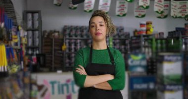 Silahlı kararlı bir hırdavatçı müdürü. Etrafı araç gereç ve ürünlerle çevrili, somutlaşmış liderlik ve girişimci ruhla dolu.