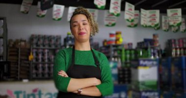 Hırdavatçıda kendine güveni tam bir dükkan sahibi, gururla gülümsüyor, profesyonel bir perakende sektöründe bağımsızlık ve iş sahibi olduğunu gösteriyor.