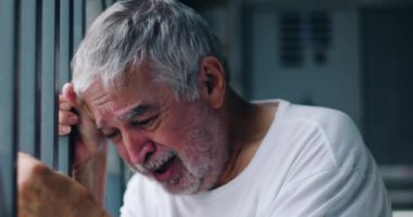 Yaşlı adam parmaklıklara yaslanıyor, yenilmiş ve kırılmış, derin keder ve duygusal acıya dalmış, umutsuzluğun dramatik tasviri, yaşlanma, ve hayatın ağırlığı mücadeleler 