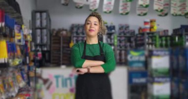 Ürünler ve aletlerle çevrili, iş yerinde profesyonellik ve liderlik sergileyen, küçük işletme hırdavatçısında kendine güveni tam bir kadın.