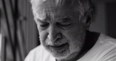 Derin keder, umutsuzluk ve duygusal acının gözyaşı dolu ifadesiyle yaşlı bir adam yalnızlık ve umutsuzluk yaşıyor, siyah ve beyaz.