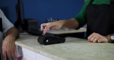 Bir nalbur alışverişi sırasında ödeme için kullanılan bir kart makinesinin odaklanmış yakın plan görüntüsü.