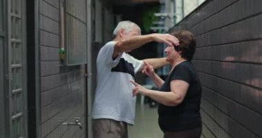 Dar bir koridorda samimi bir kucaklaşmayı paylaşan yaşlı çift, gerçek sevgi, duygusal bağ ve ihtiyarlıkta şefkat gösteriyorlar.