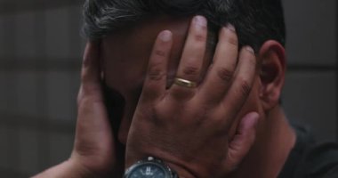 Yüzü örten ve kafasını ellerle tutan adam, umutsuzluk ve duygusal karmaşadan bunalmış, yalnızlık sırasında üzüntüyü, iç acıyı, zihinsel mücadeleyi ve umutsuzluğu ileten adam.