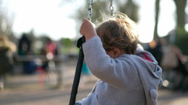 Çocuk döner ve salıncakta kıvrılır