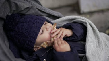 Bebek arabasındayken ekmek karbonhidratı yiyen çocuk.