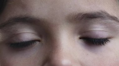 Makrodaki kameraya bakıp, 8 yaşındaki bir kızın portresini göstermenin düşünceli bakışları.