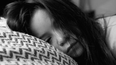 Depresyon ve duygusal üzüntüyle boğuşan, başını yastığa yaslamış genç bir kız, siyah ve beyaz, sessiz ve kasvetli bir kırılganlık anında yakalandı.