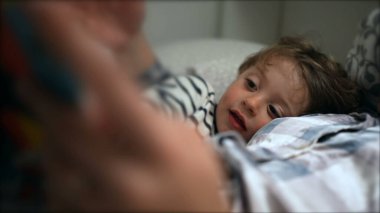 Annem geceleri uyumadan önce küçük oğluna masal okuyor.