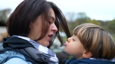 Sevgi dolu sevgi dolu bir ilişkide anne ve çocuğun özgün sahnesi, anne ve oğul arasında kucaklaşma. Sonbahar sezonunda çocuğu kollarında tutan ve ceket giyen bir ebeveyn.