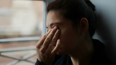 Elle gözünü ovuşturan bir kadın. Yorgun insan gözlerini ve yüzünü ovar.