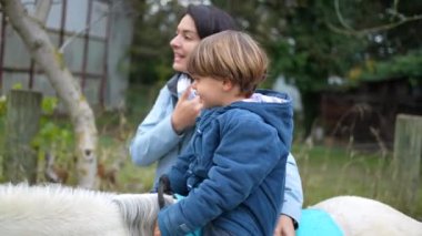 Çocuk midilliye biniyor, annesi ve oğlu güler yüzlü.