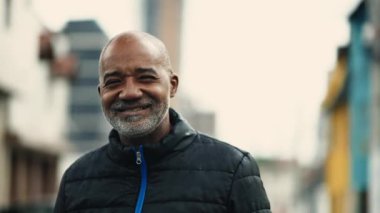 Orta yaşlı mutlu bir Afrikalı Amerikalı 'nın portresi Urban Setting' de gülümseyen, Brezilyalı olgun bir insanın hareketlerini yakından takip eden