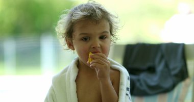 Child boy eating corn outdoors