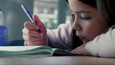 Küçük Kız 'ın Çizim ile Derinden İlgili Profili. Genç bir kızın, renkli kalemle yaratıcı bir şekilde kağıda çizim yapmaya odaklandığı profilinin detaylı bir görüntüsü.