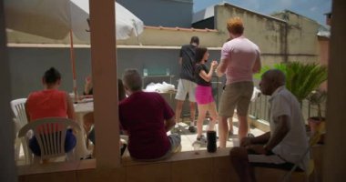 Arka bahçe aile toplantısı, çok nesilli bir grupla, insanlar rahat ve canlı bir açık hava ortamında sohbet, yemek ve bağlantının keyfini çıkarıyorlar.