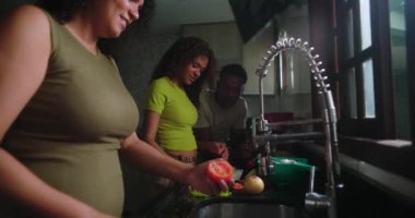 Anne sebzeleri yıkarken, aile mutfakta birlikte vakit geçirir. Genç kız yemek hazırlıklarına yardım eder. Baba da bu anın tadını çıkararak gözlemler.