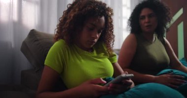 Anne Afrika kökenli kızından akıllı telefon alıyor, teknolojinin aşırı kullanımı ve ebeveynliği ele alıyor, aile dinamiklerini ön plana çıkarıyor ve dijital bağımlılığı yönetiyor.