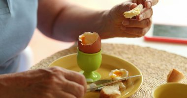 Sabah kahvaltıda ekmeğe tereyağı sürüyorum.