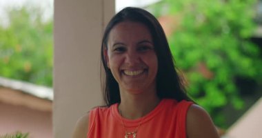 Parlak bir gülüşü olan, pozitiflik ve neşe saçan, açık havada duran, mutluluğu, sıcaklığı ve günlük hayatı sembolize eden bir kadın.