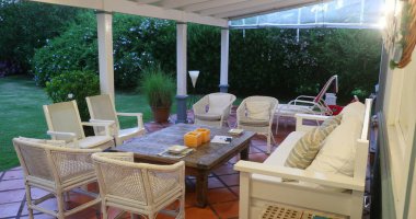 Büyük masa ve sandalyeli geleneksel sundurma.