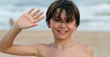Little boy child waving to camera