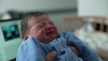 Yeni doğan bebek, hastane yatağında annesinin kollarında huzur içinde uyuyor. Bağlanma ve doğum sonrası bakımı, duygusal bağlantıyı, aile sevgisini ve sağlık hizmetleri ortamında bakımı vurguluyor. 